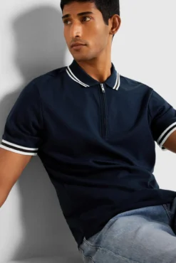 Polo de manga curta com fecho de correr, fabricado em algodão reciclado.